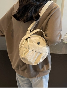 Sac bandoulière rond en nylon beige chic avec large sangle et logo M en métal