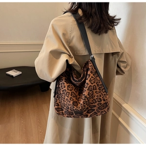 Fashionable leopard print shoulder bag worn by model in a minimalist interior setting