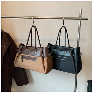 Detail of nylon tote bags with leather trim, front zipper pocket and side buckles
