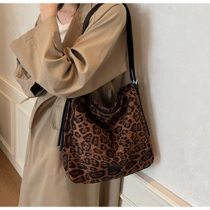 Close-up of stylish leopard print shoulder bag worn with a classic khaki trench coat
