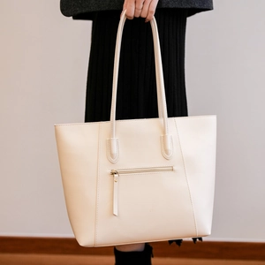 Detail view of large cream tote bag with back zipper pocket and slim shoulder straps