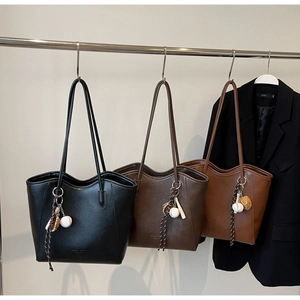 Minimalist PU leather tote bags in black and brown with baseball glove bag charms