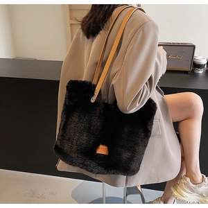 Detail of black faux fur tote bag showing plush texture and brown leather shoulder straps