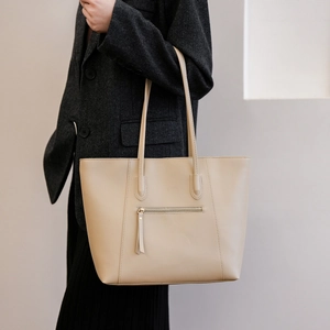 Detail of minimalist beige leather tote bag with front zipper pocket for business commute