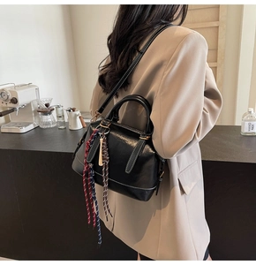 Dettaglio della borsa Boston in pelle nera opaca con nappa intrecciata colorata