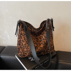 Detail of leopard print tote bag with black leather strap and stylish side fringe zipper