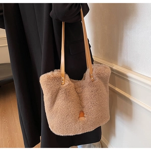 Detail of soft khaki faux fur tote bag with leather straps and metal rivets for winter