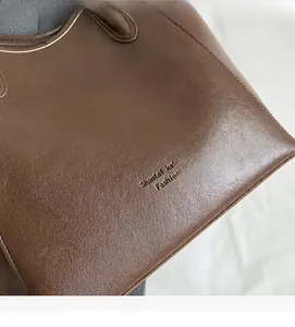 Detailed macro view of the dark brown PU leather texture with embossed fashion lettering