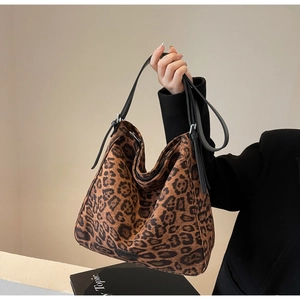 Detail of spacious leopard print tote bag with black double straps and soft hobo shape