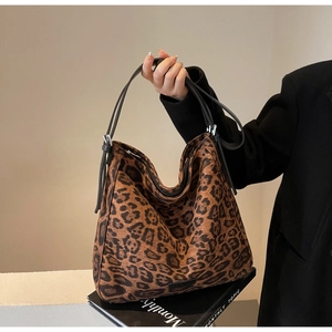 Detail view of leopard print hobo bag showing adjustable silver buckles and texture