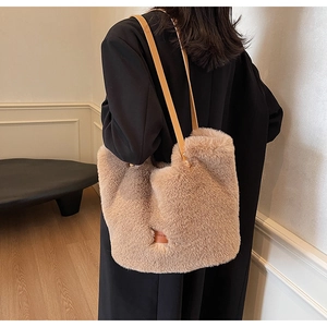 Detail view of large plush tote bag in beige with long slim brown leather shoulder straps