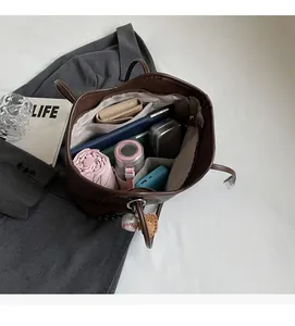 Interior view of brown tote bag showing capacity for tablets and daily essentials