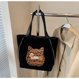 Close-up of black suede tote bag with leopard cat pattern and dachshund embroidery detail