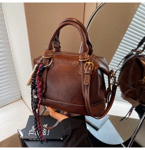 Vista dettagliata di una borsa Boston vintage marrone scuro con cuciture bianche a contrasto