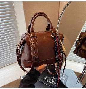 Dettaglio della borsa Boston vintage marrone con cuciture bianche e corda intrecciata