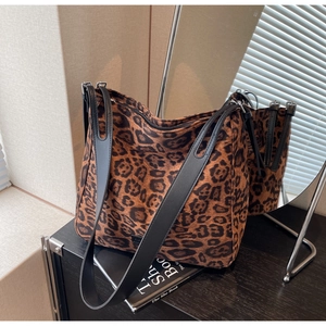 Macro detail of leopard print shoulder bag featuring premium black wide faux leather straps