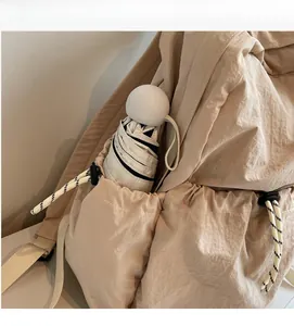 Détail de la poche latérale du sac à dos en nylon avec cordon et parapluie plié