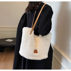Close-up of white faux fur tote bag with brown leather straps and square logo patch
