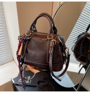 Dettaglio borsa a mano vintage in pelle testa di moro con cuciture e ciondolo intrecciato