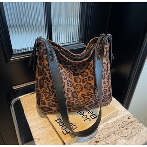 Close-up of leopard print tote bag with black leather strap and 'FASHION & BAG' label