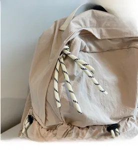 Gros plan sur la fermeture éclair fluide avec tirette tressée bicolore sur sac à dos en nylon