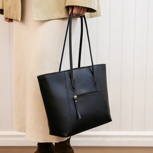 Detail view of the functional rear zipper pocket on this minimalist black leather tote bag