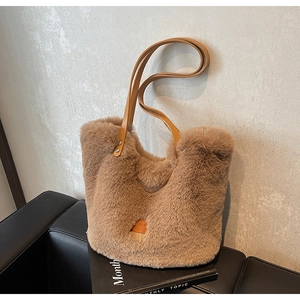 Close-up of light brown faux fur bucket bag featuring leather straps and embossed label