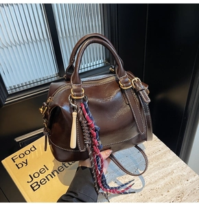 Dettaglio borsa Boston marrone scuro lucida con ciondolo in corda intrecciata retrò