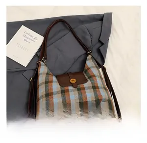 Détail du sac à bandoulière vintage à carreaux avec sangle en cuir et boucle métal