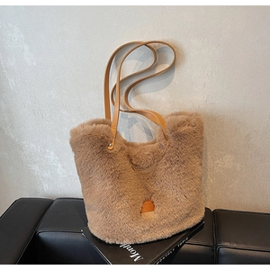 Close-up of brown plush tote bag with leather strap and soft faux fur texture
