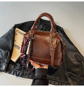 Dettaglio della borsa Boston vintage marrone con cuciture bianche e finiture retrò