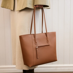 Close-up of brown PU leather tote bag with functional back zipper pocket and slim straps