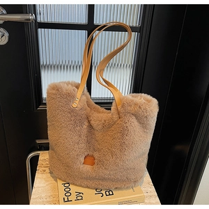 Detail of plush tote bag showing light coffee faux fur and leather logo tag texture
