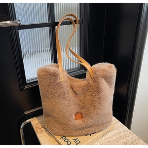 Detail of camel plush tote bag with leather logo patch and sturdy shoulder strap