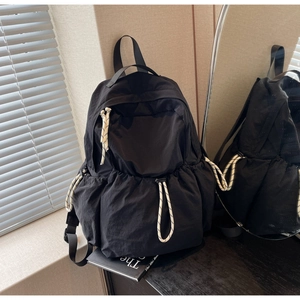 Vue détaillée du sac à dos noir en nylon avec tirettes de fermeture éclair bicolores