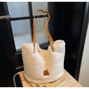 Close-up of white faux fur tote bag with brown PU straps and metallic rivets details