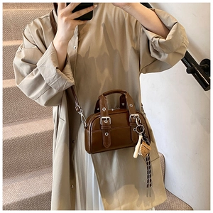 Détail du sac en cuir PU marron avec boucles en métal et breloques à pompons