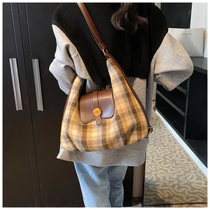 Gros plan détaillé du sac à carreaux avec rabat en cuir marron et fermoir doré chic