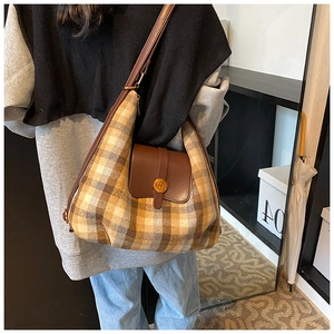 Détail du sac hobo à carreaux vintage avec rabat en cuir et bandoulière réglable