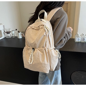 Détail du sac à dos de voyage en nylon beige avec poches à cordon et cordons tressés