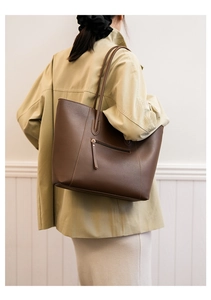 Detailed back view of a large brown faux leather tote bag with a functional zipper pocket
