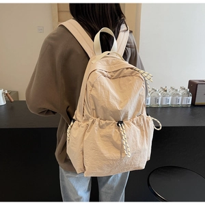 Détail du sac à dos en nylon crème avec poches à cordon et bretelles ajustables