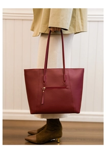 Burgundy tote bag featuring a practical rear zipper pocket and smooth leather texture