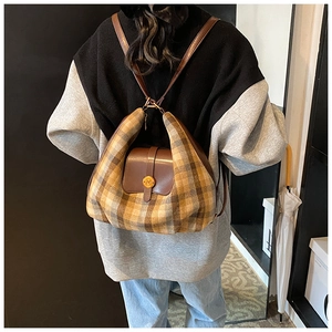 Détail du motif à carreaux rétro et du rabat en cuir marron sur le sac à dos