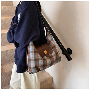 Vue détaillée du sac à carreaux avec rabat en cuir marron et fermoir doré chic