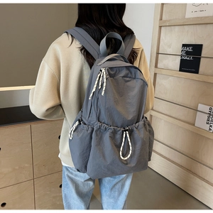 Détail d'un grand sac à dos de voyage en nylon gris avec tirettes de zip tissées