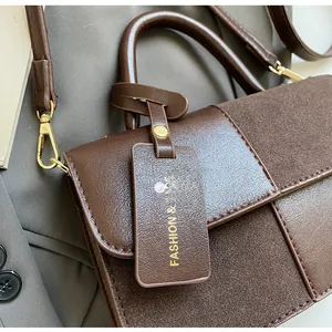 Detalle de costuras de cuero PU marrón oscuro y herrajes dorados en bolso bandolera