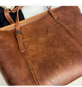 Détail montrant la texture du cuir gras marron vintage et le tissu doux du grand sac cabas