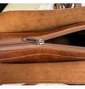 Détail de la fermeture éclair argentée et de la doublure intérieure du sac en cuir brun