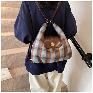 Détail du sac à dos vintage à carreaux avec rabat en cuir brun et boucle dorée logo N